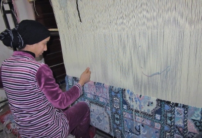 weaving a traditional silk rug, Fez, Morocco.